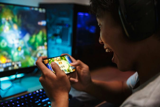 boy gaming on pc and phone