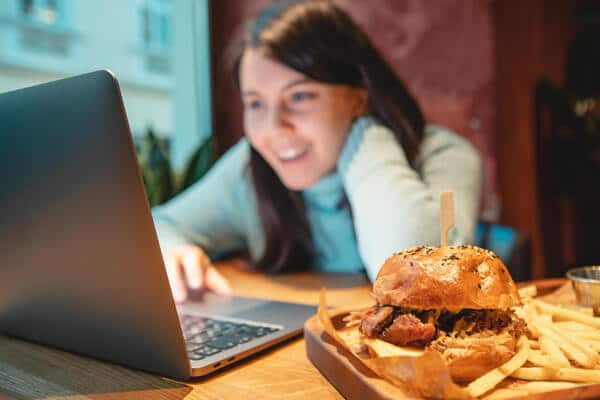 Teen on computer with food